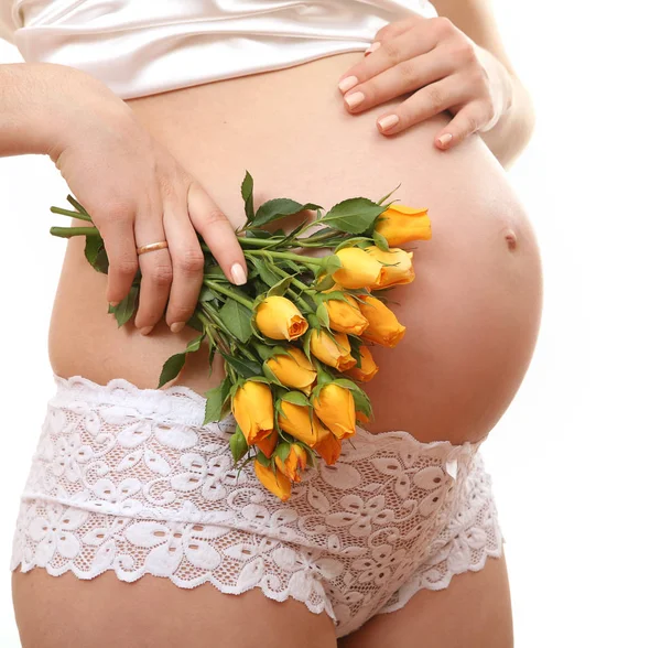 Беременная женщина с розами в руке — стоковое фото
