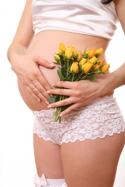 Беременная женщина с розами в руке — стоковое фото
