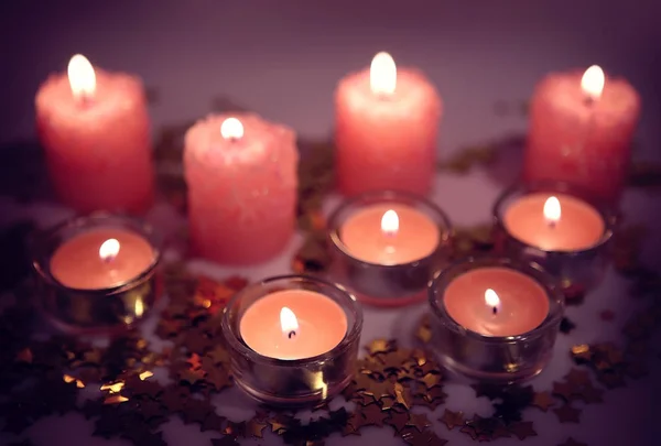 Burning decorative candles and confetti — Stock Photo, Image