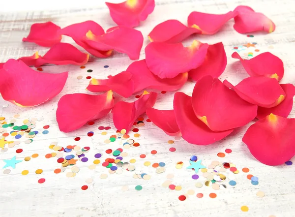 Pétalos de rosa roja y confeti — Foto de Stock