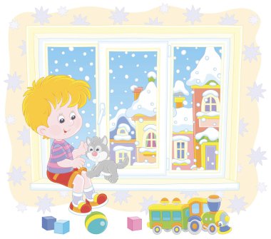 Küçük gri kediciğiyle karlı bir kış gününde bebek odasının penceresinde oynayan gülümseyen çocuk, çizgi film tarzında vektör çizimi.