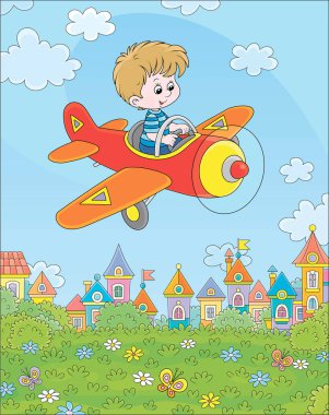 Küçük çocuk küçük oyuncak uçağını mavi yaz gökyüzünde beyaz bulutların arasında güneşli bir günde küçük bir kasabanın şirin renkli evleri yakınındaki yeşil bir parkın üzerinde kullanıyor.