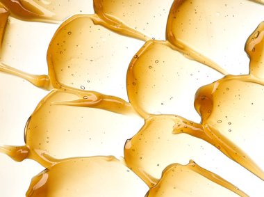 Yüz kremi veya altın şeffaf sarı smear izole üzerinde beyaz arka plan tatlım. Beyaz zemin üzerine altın krem honet doku