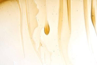 Yüz kremi veya altın şeffaf sarı smear izole üzerinde beyaz arka plan tatlım. Beyaz zemin üzerine altın krem honet doku