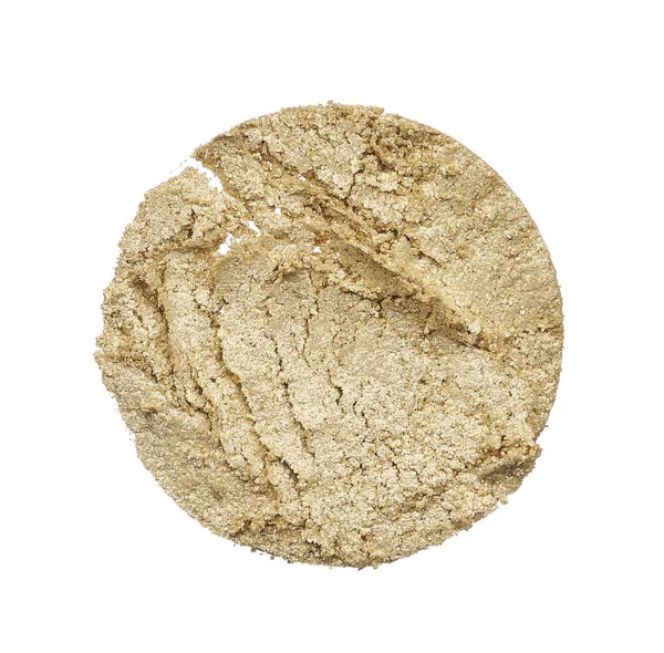 Crushed texture of beige eye shadow isolated on white background. Texture of broken golden powder on white background
