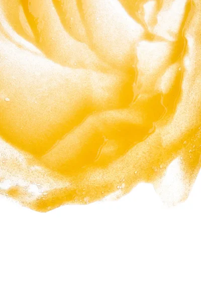 Smear of orange sugar scrub for body and lips are isolded on a white background. Texture of cosmetic body scrub orange color