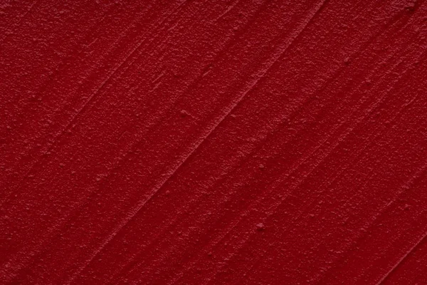Red matte texture of lip gloss background. Red creamy lipstick texture background