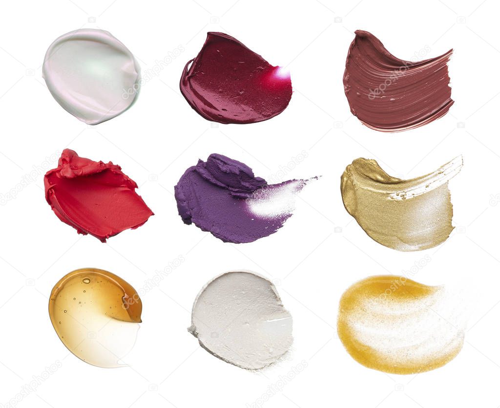 Smears of different colors are made by various cosmetic products isolated on a white background. Texture of multi-colored strokes of various make-up cosmetics on a white background