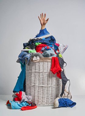 Gri arka plan üzerinde bir elinizi ile tam Çamaşırhane beyaz hasır sepet