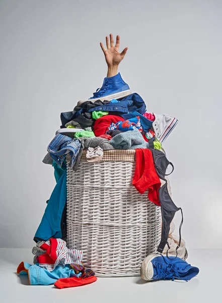 Gri arka plan üzerinde bir elinizi ile tam Çamaşırhane beyaz hasır sepet