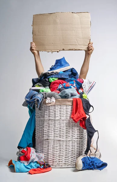 Tam Çamaşırhane gri arka plan üzerinde beyaz hasır sepet. İki el bir karton tablet tutun