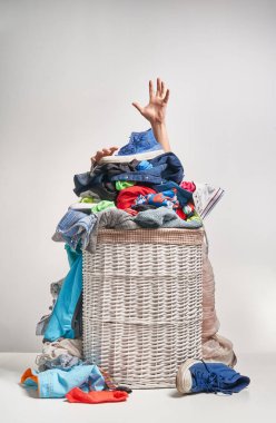 Gri arka plan üzerinde bir elinizi ile tam Çamaşırhane beyaz hasır sepet