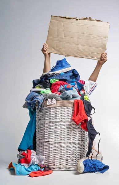 Tam Çamaşırhane gri arka plan üzerinde beyaz hasır sepet. İki el bir karton tablet tutun