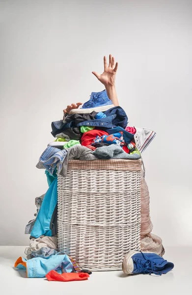 Gri arka plan üzerinde bir elinizi ile tam Çamaşırhane beyaz hasır sepet