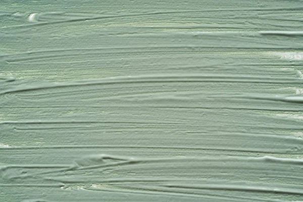 Gently green strokes and texture of face cream or acrylic paint isolated on white background