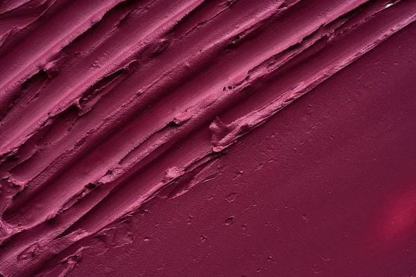 Smears and texture of  burgundy color lipstick or acrylic paint on a white background