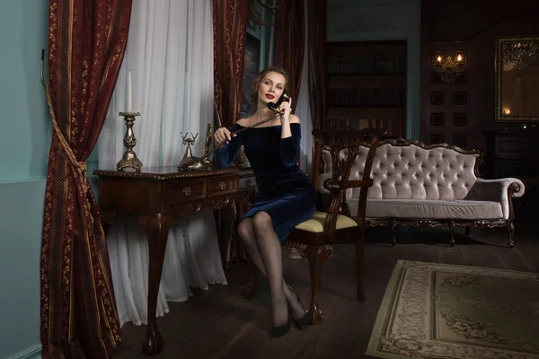 Beautiful attractive woman in the vintage interior speaks by phone