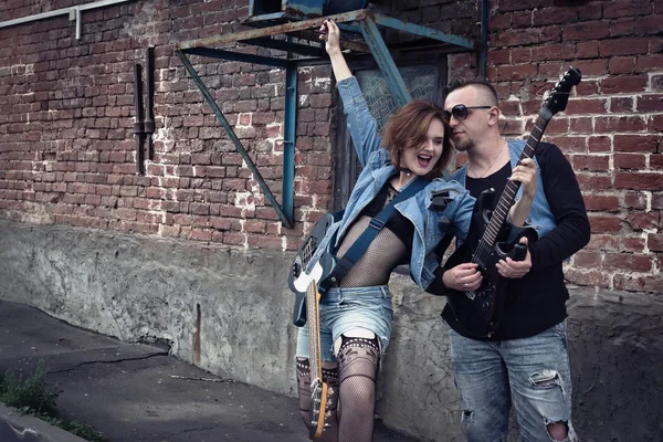 街の通り上の女の子と男のパンクをギターに再生します — ストック写真