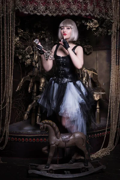 Pretty gothic girl in a dark room interio