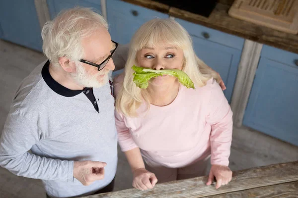 Ηλικιωμένο ζευγάρι έχει τη διασκέδαση στην κουζίνα. — Φωτογραφία Αρχείου