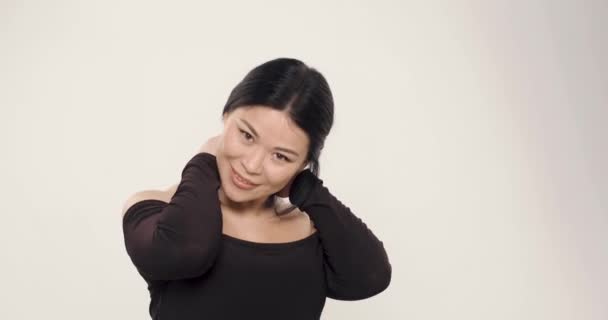 Lässige asiatische Frau isoliert auf weißem Hintergrund — Stockvideo