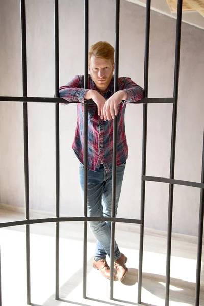 Guy behind metal bars. — Stock Photo, Image