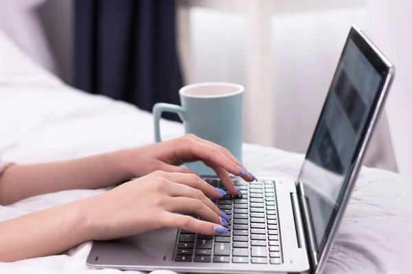 Jonge dame met laptop in bed. — Stockfoto