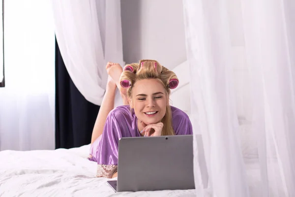 ベッドでノート パソコンを持つ若い女性. — ストック写真