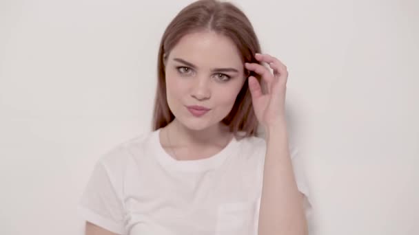 Young woman posing and smiling over white background — Stock Video