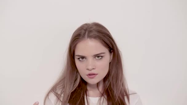 Mladá žena, pózování a usmívá se na bílém pozadí — Stock video