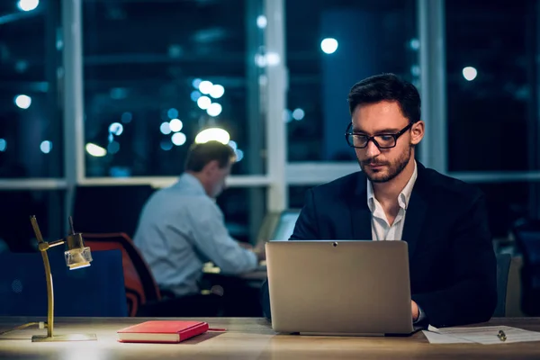 Joven hombre de negocios que se queda hasta tarde trabajando . — Foto de Stock