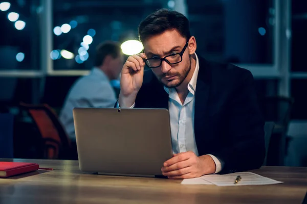 Joven hombre de negocios que se queda hasta tarde trabajando . — Foto de Stock