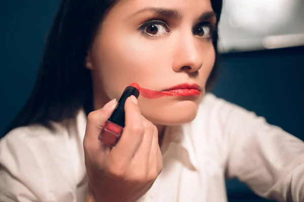 Gek vrolijke vrouw toepassing van lippenstift. — Stockfoto