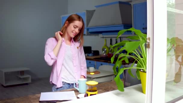 Charmante jonge vrouw stond in de keuken drinken thee of koffie. — Stockvideo