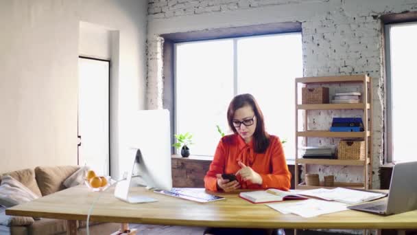 Femme d'affaires utilisant son téléphone intelligent au bureau . — Video