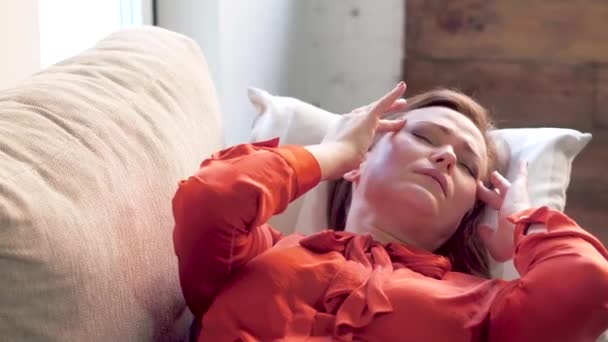 Woman laying on sofa with headache. — Stock Video