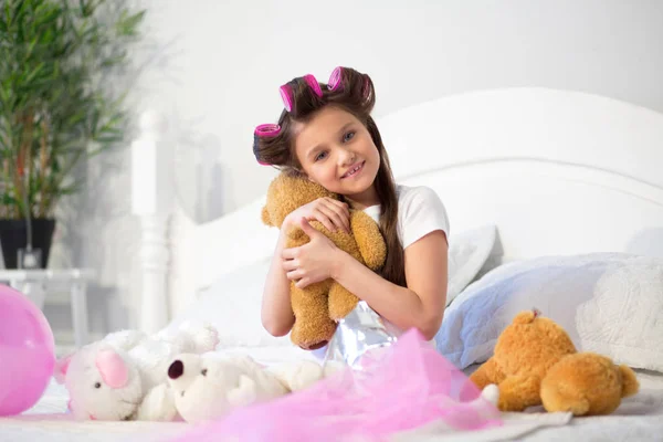 Menina em sua cama com brinquedo macio . — Fotografia de Stock
