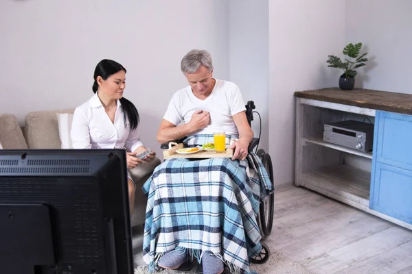 Hemşire hasta tekerlekli sandalyede yiyecek getirmek. — Stok fotoğraf