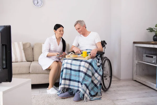 Nurse bringing food to patient in wheelchair. — Stock Photo, Image