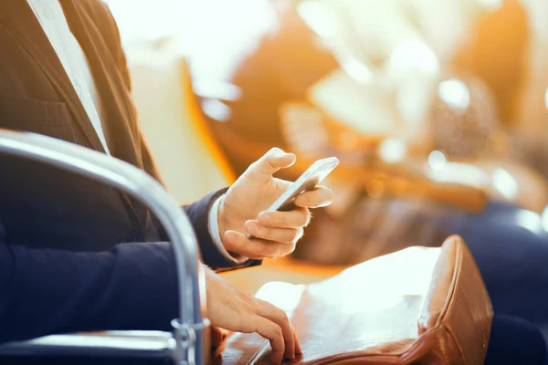 Geschäftsmann mit seinem Handy in der U-Bahn. eleganter junger Geschäftsmann steckt sein Handy in seine braune Ledertasche, während er in der U-Bahn sitzt. — Stockbild Geschäftsmann Mit Seinem Handy Der Bahn Eleganter Junger Geschäftsmann Steckt — Stockfoto