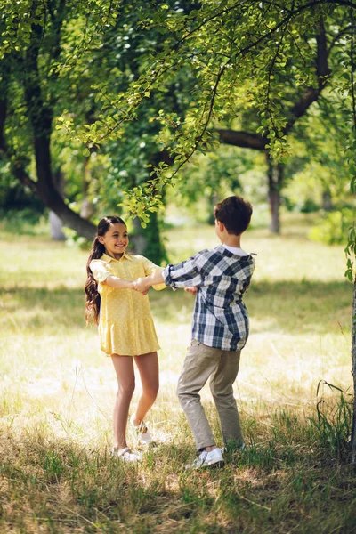 Little boy and girl spinning around. — Stock Photo, Image