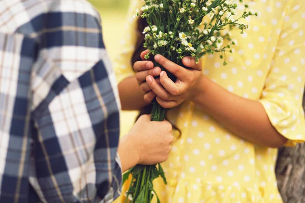 Pequeño niño dando bouqet de flores a la niña . — Foto de Stock