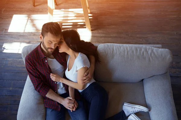 Casal feliz sentado no sofá . — Fotografia de Stock