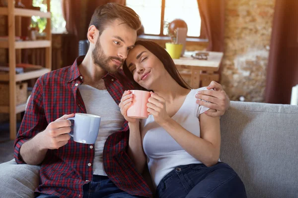 Casal feliz sentado no sofá . — Fotografia de Stock