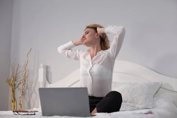 Geschäftsfrau sitzt auf Bett und arbeitet — Stockfoto