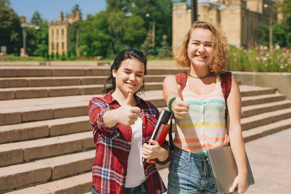 Daumen hoch für zwei glückliche Studenten. — Stockfoto