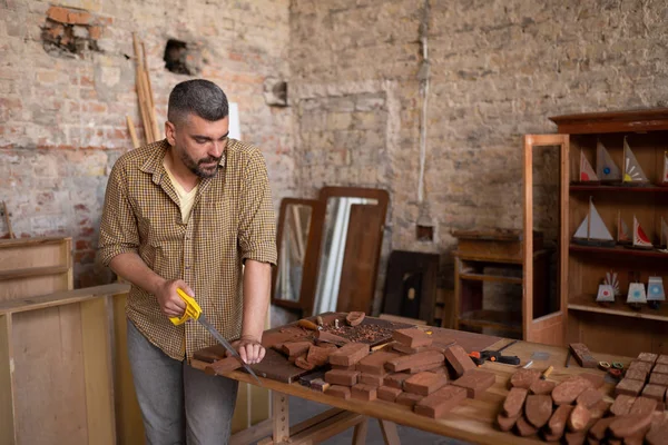 El carpintero experto corta un pedazo de madera — Foto de Stock