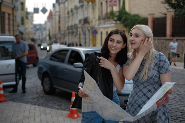 Dos encantadoras mujeres alegres están caminando con el mapa — Foto de Stock