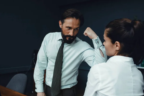 Business people showing muscles in office — Stock Photo, Image