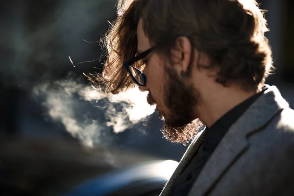 Uzun saçlı bir adam dışında sigara içiyor — Stok fotoğraf